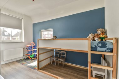 Evinde çeşitli oyuncaklarla dolu yatağı olan modern bir çocuk odası.