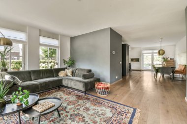 Çağdaş dairenin geniş odasında dinlenme odası ve mutfağı olan sandalyeli bir masa.