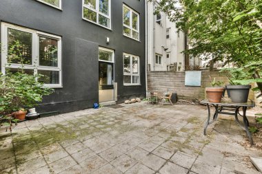 Neat powerful patio with sitting area and small garden near wooden fence