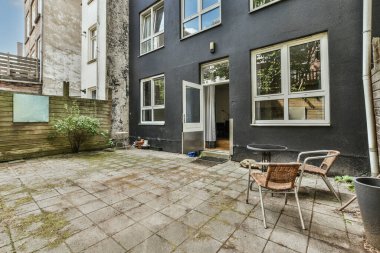 Neat powerful patio with sitting area and small garden near wooden fence