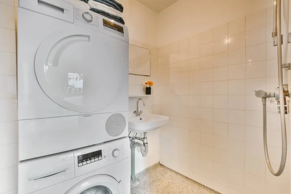 a laundry room with a washer, dryer and toiletries in the corner next to the shower stall