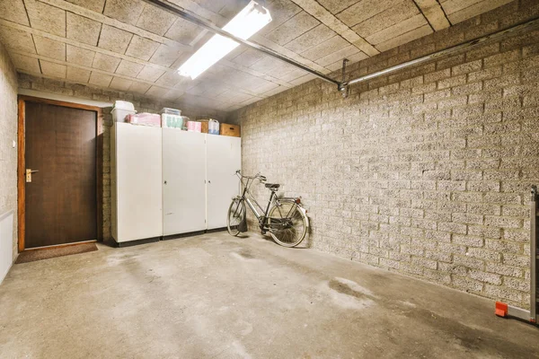 a room with a bike parked in the corner and an open door leading to another room that has been painted white