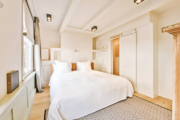 a bedroom with a bed, dresser and mirror on the wall in front of the room is very clean white
