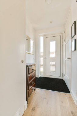 Beyaz duvarları ve ahşap döşemeleri olan boş bir oda sağ tarafta açık, siyah bir halı var.