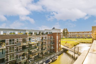 Suyun üzerinde binaları ve tekneleri olan bir kentsel alan. Görüntü yüksek bir açıdan çekiliyor.