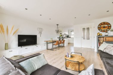 Oturma odası, kanepeleri ve duvarları olan bir televizyon odası. Odanın ortasında bir eğlence alanı.