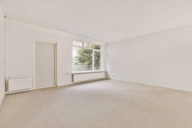 Beyaz duvarları ve zemini olan boş bir oturma odası sağda sokağa bakan büyük bir pencere var.