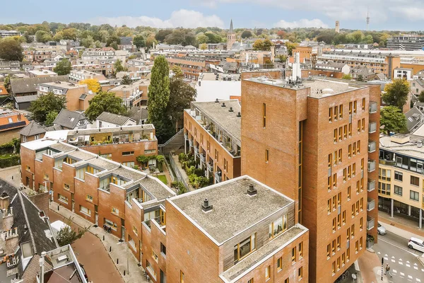 an aerial view from the top of a tall brick building in portlands downtown neighborhood, with trees and buildings on both sides