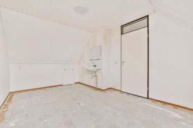 Beyaz duvarları olan boş bir oda ve solundaki diğer duvarda kimse yok.