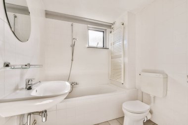 Lavabosu, tuvaleti ve küveti olan bir banyo duvarın diğer tarafında aynı odada.