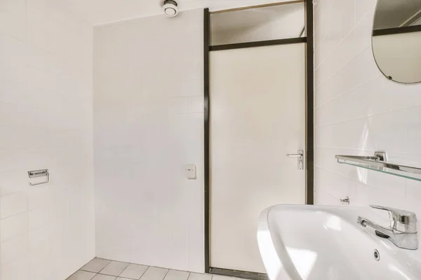 a bathroom with white tiles and black trim around the shower door, which has been replaced to make it look more modern