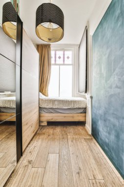 Odanın zemininde ahşap döşeme ve duvarları tahtayla kaplanmış bir yatak odası.