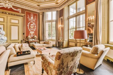 Koltukları, sandalyeleri ve tabloları olan bir oturma odası.