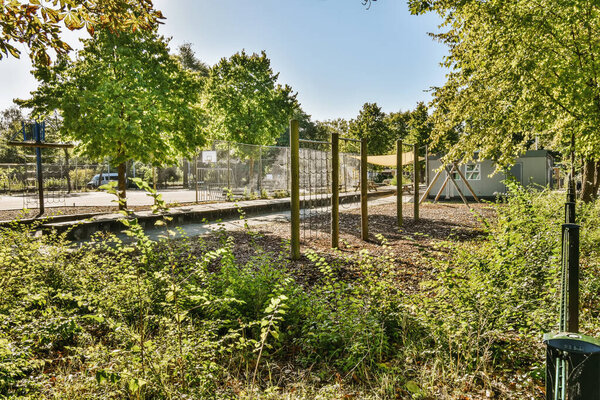 an urban park with trees and plants in the foreground, as well for children to play or walk around