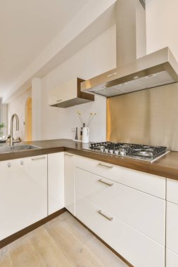 Beyaz dolapları ve ahşap tezgahları olan modern bir mutfak.