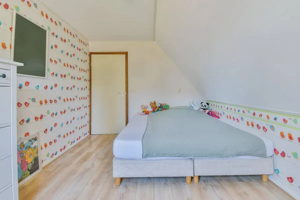 a childs bedroom with colorful wallpapers on the walls and white furniture in front of the bed