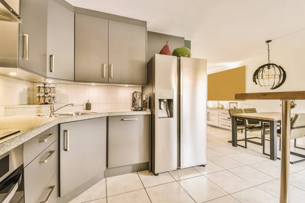 a kitchen and dining area in a small apartment with stainless steel appliances on the counter, sink, refrigerator and dishwasher