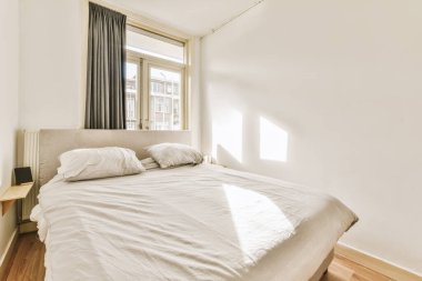 Odanın sağ tarafında yatak odası, penceresi ve lambası olmayan bir oda.