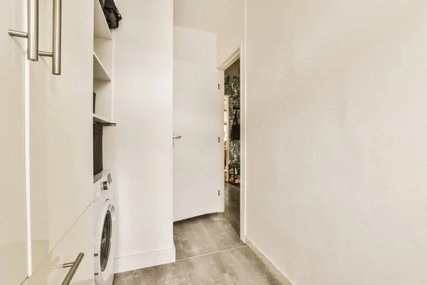 a laundry room with a washer and dryer on the floor in front of the door to the bathroom