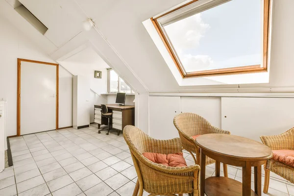 a kitchen and dining area in an attic style home with skylights on the roof, white walls and tiled floor