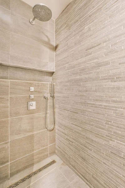 a bathroom with tile on the walls and shower head mounted to the wall, it is clean and ready for use