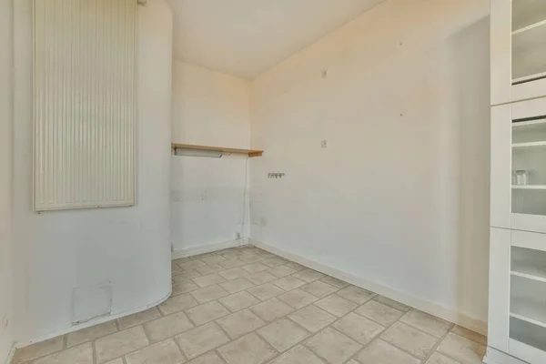 an empty room with tile flooring and white cupboards on either side of the room there is no one in it