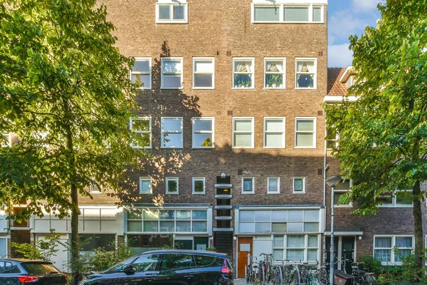 Yol kenarına park etmiş bir apartmanın önüne park etmiş bir sürü pencere ve balya var.