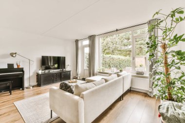 Ortasında piyano, diğer tarafında televizyon olan bir oturma odası.