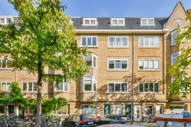 Hollanda 'da bir apartman kompleksi. Sokağa park edilmiş bisikletleri ve kaldırımlı yol boyunca park edilmiş arabaları var.