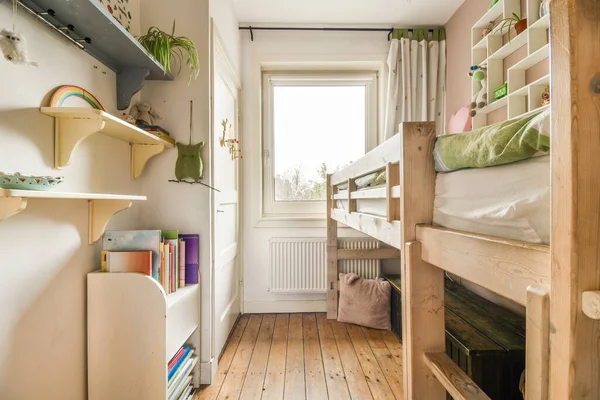 stock image a small room with bunks and other items on the floor in front of a window that looks out onto the street