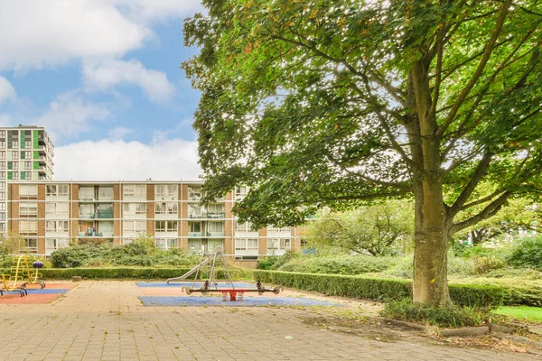 an apartment complex with playgrounds and play areas in the foreground area, near to londons hyde park