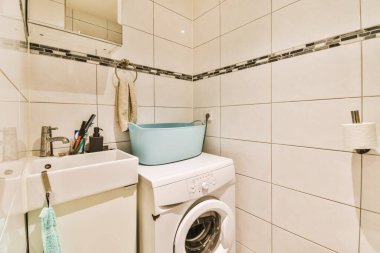 Çamaşır yıkama ve kurutma makinesi olan bir çamaşır odası. Banyodaki çamaşır makinesinin yanında.