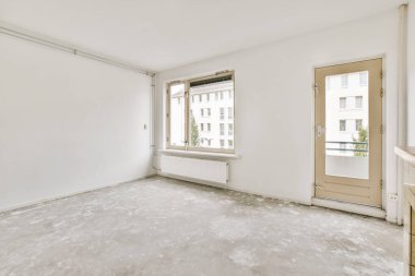 Beyaz duvarları olan boş bir oda ve sağ tarafında hiç kapı yok. Duvarda bir pencere var.