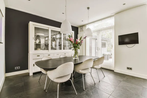 a modern dining room with black walls and white trim around the window simh is on the right wall
