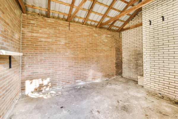 an unfinished room with brick walls and wood beams on the ceiling in a new house under construction project stock photo