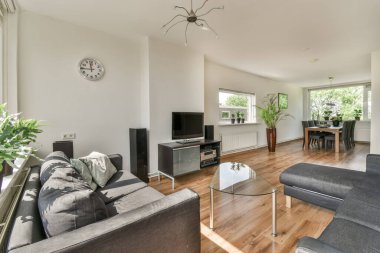 Sağ taraftaki odanın ortasında kanepeleri ve televizyonu olan bir oturma odası yemek masası.