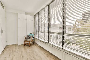 a room with wood flooring and white shutters on the windows looking out onto an outside cityscapea clipart