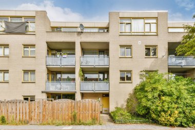 Balkonlarda balkon ve ön bahçelerde balkon olan bir apartman dairesi.