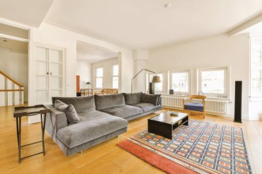 a living room with hardwood flooring and white trim on the walls there is a couch, coffee table, television stand, and