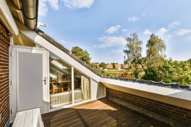 an outside area with wood flooring and white trim on the walls, windows, doors, and railings