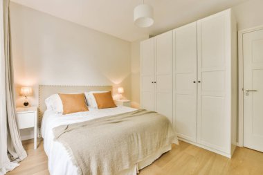a bedroom with a bed and closets in the corner, taken from the side to show how its done