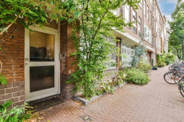 some bikes parked on the side of a street in front of a brick building with ivys growing around it