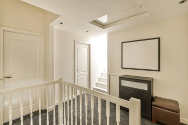 Duvarlarında beyaz süsleme olan boş bir oda ve sağdaki kapının arasında bir şömine.