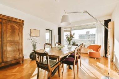 a dining room with wood flooring and white walls in the room is framed by a large wooden door that leads to an open