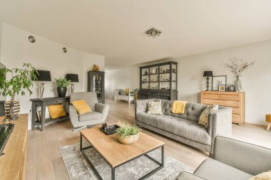 Oturma odası, iki kanepe ve bir sehpa ile ön taraftan yemek alanına doğru çekiliyor.