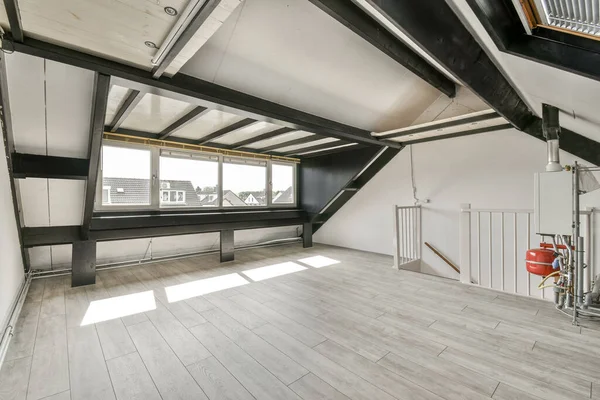 stock image an empty room with wood flooring and white walls, there is a window in the wall that looks out to the city