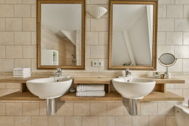 two sinks in a bathroom with mirrors on the wall and one sink is sitting next to each other sinks,