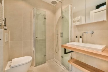 Lavabosu, tuvaleti ve duşu olan bir banyo duvarın diğer tarafında aynı odada.