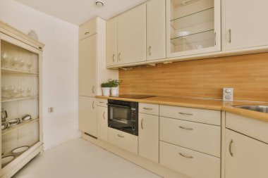 a kitchen with white cupboards and wood counter tops on the wall in this photo is taken from the inside
