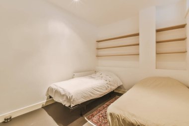 Arkasındaki duvarda yatak odası ve raflar var. Depoya yerleştirilmiş.